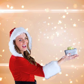 Sexy santa girl holding gift against bright star pattern on cream