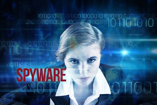 The word spyware and focused businesswoman against blue technology design with binary code