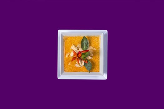 gang dang. Asian Thai food on white plates with purple background with copy space with green vegetable an
