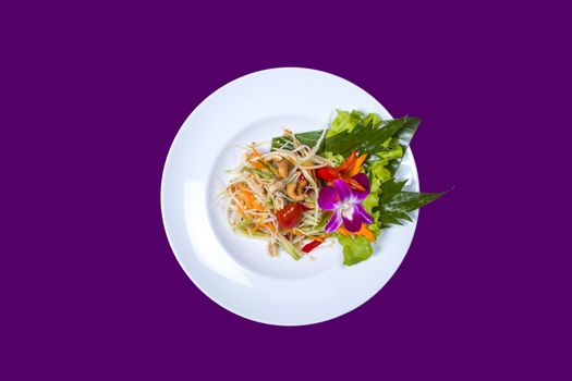 Som tam. Asian Thai food on white plates with purple background with copy space