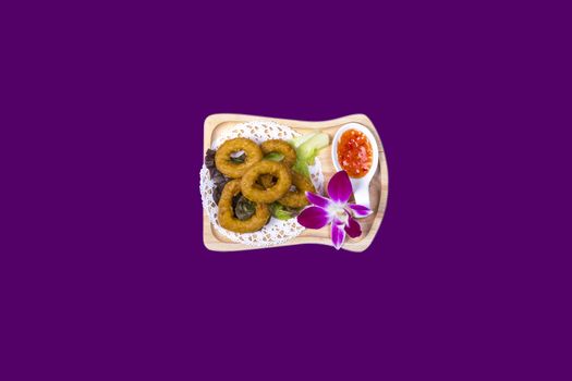 Salt and pepper. Onion rings. Asian Thai food on white plates with purple background with copy space