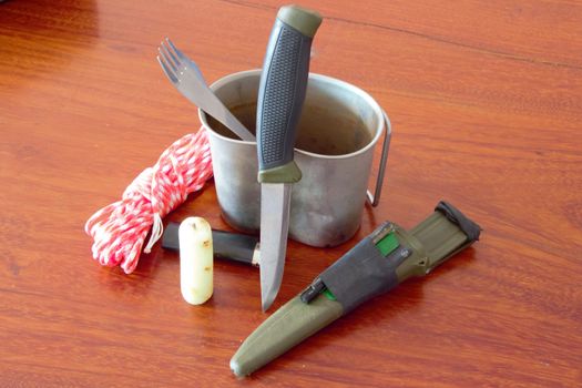 survival kit with knife, steel mug, candle and paracord