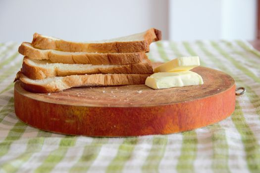 slices of bread on a wooden board with butter
