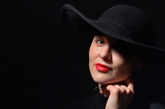 A Woman With Red Lips In A Black Hat On A Black Background