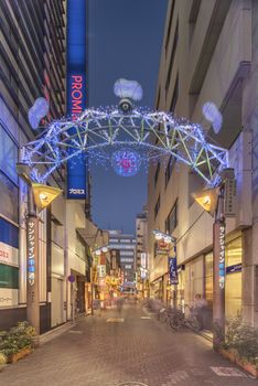 Illuminated entrance gate with security camera operating at the Sunshine Central Street connecting the east exit of Ikebukuro station lines with yakitori and sushi restaurants, shops, game center and cinemas leading to the famous otaku's town otome road.