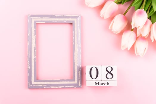 Happy Women's Day, Mother's Day concept. top view flat lay Tulip flower and photo frame on pink background, copy space for your text