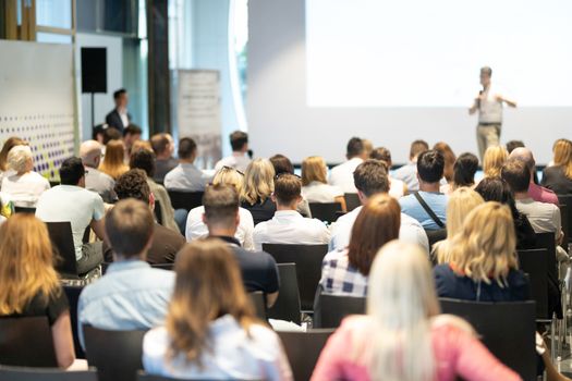 Speaker Giving a Talk at Business Meeting. Audience in the conference hall. Business and Entrepreneurship. Panoramic composition suitable for banners.