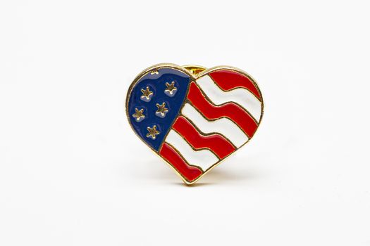 close up of a USA heart flag pin isolated against a white background
