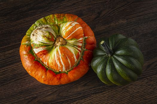 two squash against a dark wood background