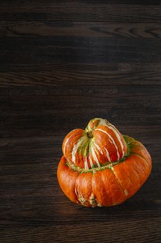 singe turban squash against a dark wood background