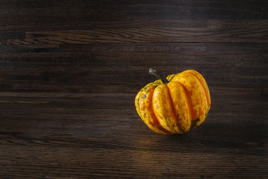 single orange sweet dumpling against a dark wood background
