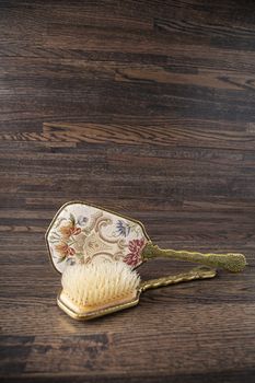 vintage beauty hair brush and mirror against a wood background