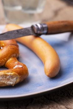 pretzel with frankfurt sausage on a plate