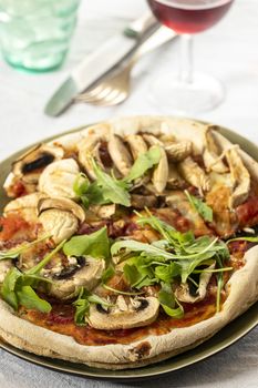 mushroom pizza on a plate with arugula