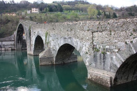 The suggestive and famous Ponte della Maddalena of Lucca built in bricks over a river in an ancient medieval village in Borgo a Mozzano