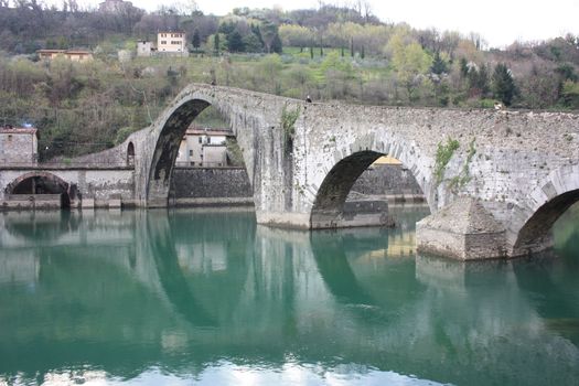 The suggestive and famous Ponte della Maddalena of Lucca built in bricks over a river in an ancient medieval village in Borgo a Mozzano