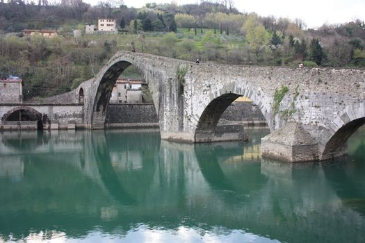 The suggestive and famous Ponte della Maddalena of Lucca built in bricks over a river in an ancient medieval village in Borgo a Mozzano