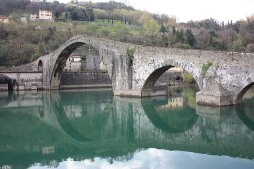 The suggestive and famous Ponte della Maddalena of Lucca built in bricks over a river in an ancient medieval village in Borgo a Mozzano