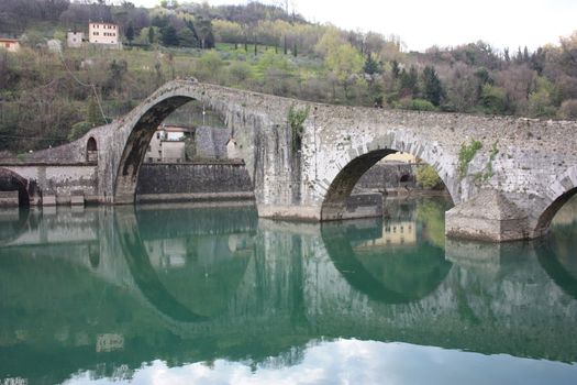 The suggestive and famous Ponte della Maddalena of Lucca built in bricks over a river in an ancient medieval village in Borgo a Mozzano