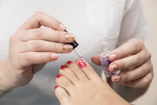 Nails care. Pedicure beauty salon. Pedicure Master does the procedure to the client