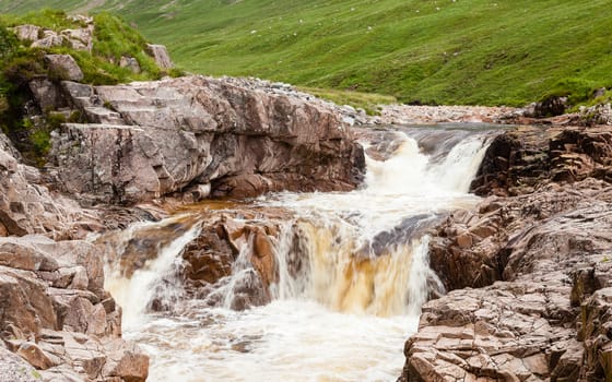 Water cascades down the River Etive in Glen Etive in the Scottish highlands.