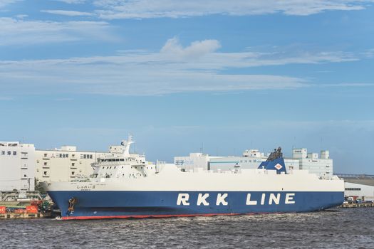 Giant cargo ship Shurei II from RKK LINE with the flag of Japan moored in the commercial port of Tokyo Bay.