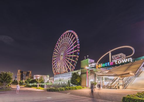 Odaiba illuminated Palette Town Ferris wheel named Daikanransha visible from the central urban area of Tokyo in the summer night sky. Passengers can see the Tokyo Tower, the twin-deck Rainbow Bridge, and Haneda Airport, as well as central Tokyo during their ride.