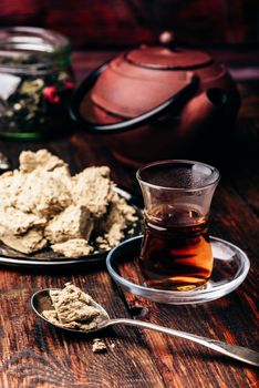 Black tea in armudu glass and spoonful of sunflower halva
