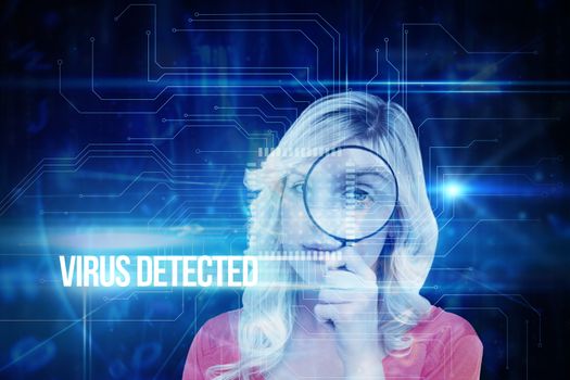 The word virus detected and fair haired woman looking through a magnifying glass against blue technology interface with circuit board