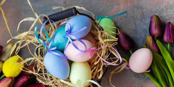 Floral easter card concept with tulips and eggs on concrete background with copy space