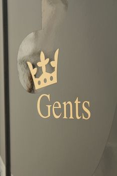 gents toilette icon on grey door with a crown