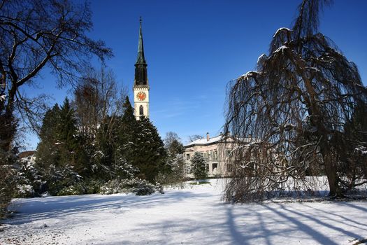 public park with church in Cham, Switzerland public park with church in Cham, Switzerland with tree and snow