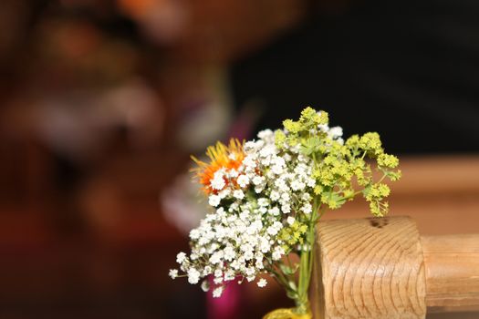 wedding flower in Church seats. white and yellow flowers with green leafs