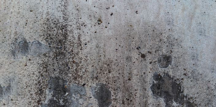 grey cement wall with dark spots l with dirt spots for background use.