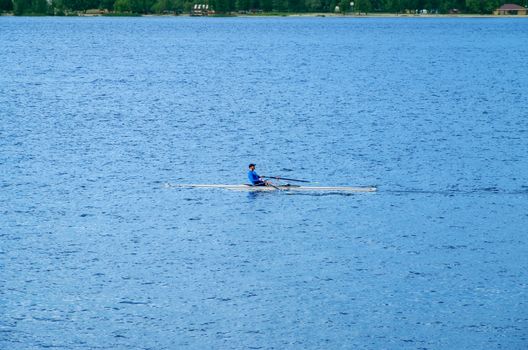 Dnipro, Ukraine - May 15, 2014: Sportsman on a single boat during a morning workout on the rowing channel