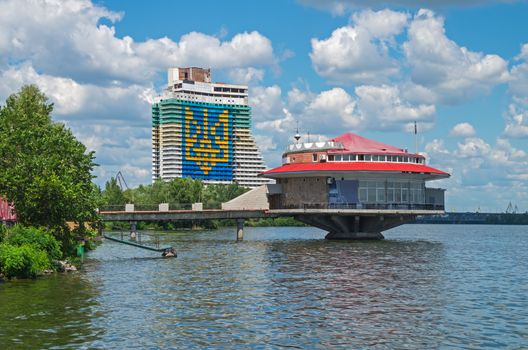 The disk-shaped house with red roof and the State Emblem of Ukraine.