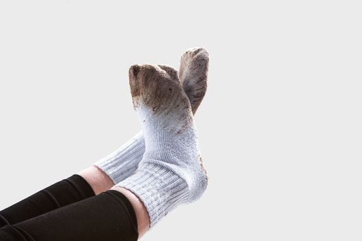 Dirty white socks ready for laundry on feet sticking up into the air
