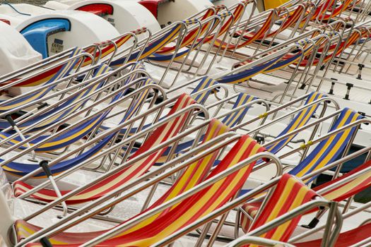 Row of colorful chaise lounge on beach. Multicolored in a row.