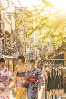 Young women in yukata in the the old-fashionned shopping street Yanaka Ginza famous as a spectacular spot for sunset. Yanaka Ginza is also named the Evening Village.