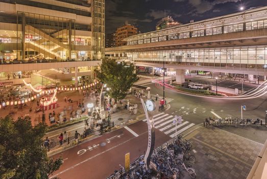 View of the square in front of the Nippori train station decorated for the Obon festival with illuminated paper lanterns  in the summer night with a yagura tower and paper lanterns in the Arakawa district of Tokyo.