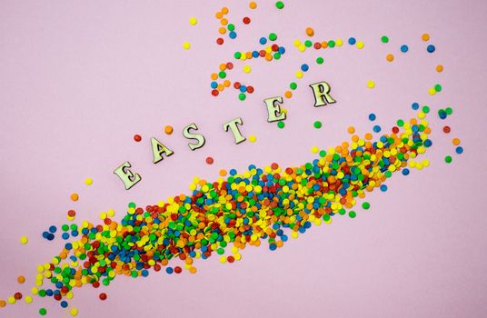 Abstract easter card with scattered color confectionery balls and letters. Easter holiday concept