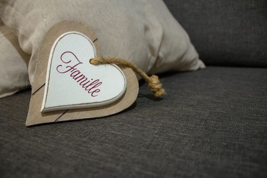 A heart shaped wood decoration board saying "Famille", or Family in english