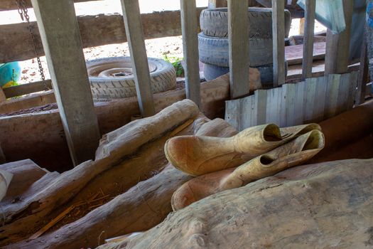 Inside an agriculture barn, showing old boots, tires, troughs and scrap woods