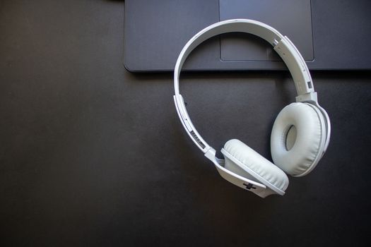 Wireless headphone resting on a laptop on a office desk