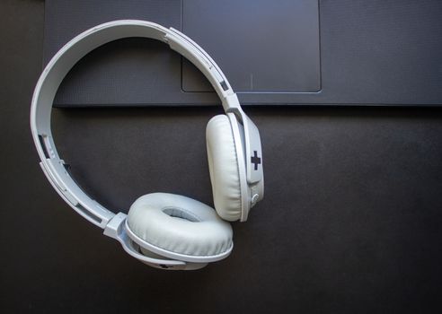 Wireless headphone resting on a laptop on a office desk