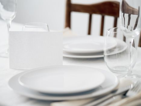 Beautiful table setting in white colors. Empty white plates. Set table for romantic dinner for two at home