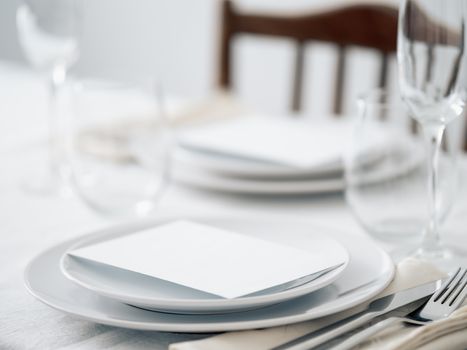 Beautiful table setting in white colors. Empty white plates. Set table for romantic dinner for two at home