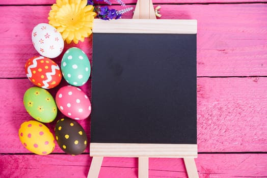 Easter eggs top view on pink wooden background and have board work space board for use