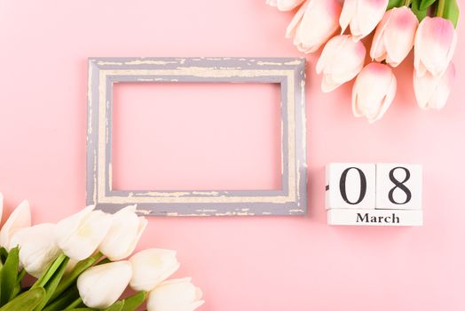 Happy Women's Day, Mother's Day concept. top view flat lay Tulip flower and photo frame on pink background, copy space for your text