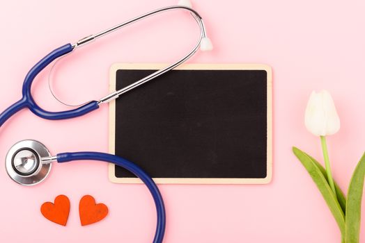 Doctor's Day concept, flat lay top view, equipment medical red heart stethoscope on pink background, care patient in hospital with black board copy space for text